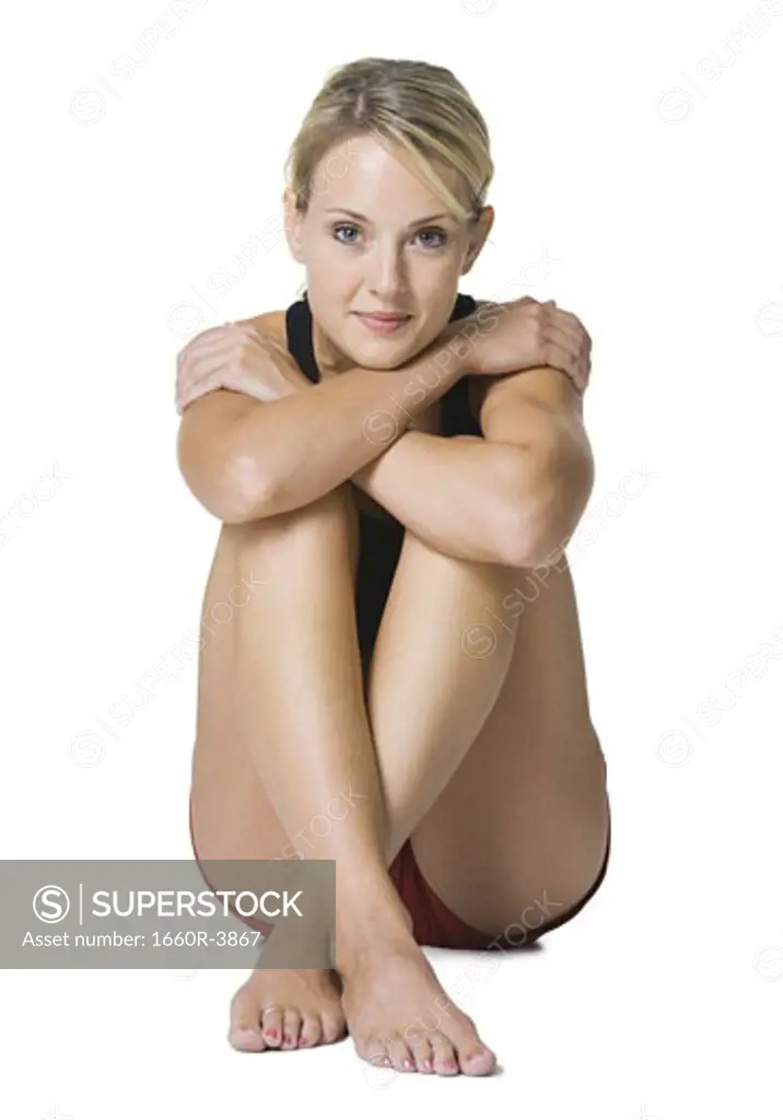 Portrait of a young woman sitting with her legs folded