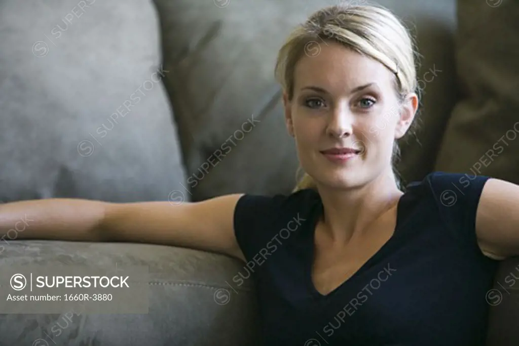 Portrait of a young woman leaning on a couch