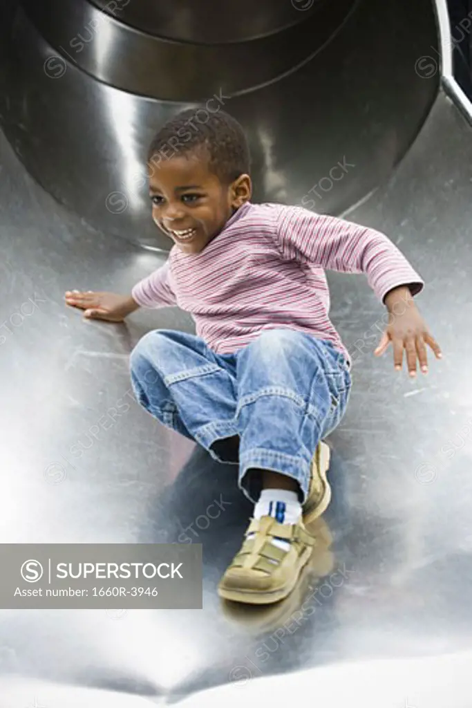 Low angle view of a boy sliding down a slide