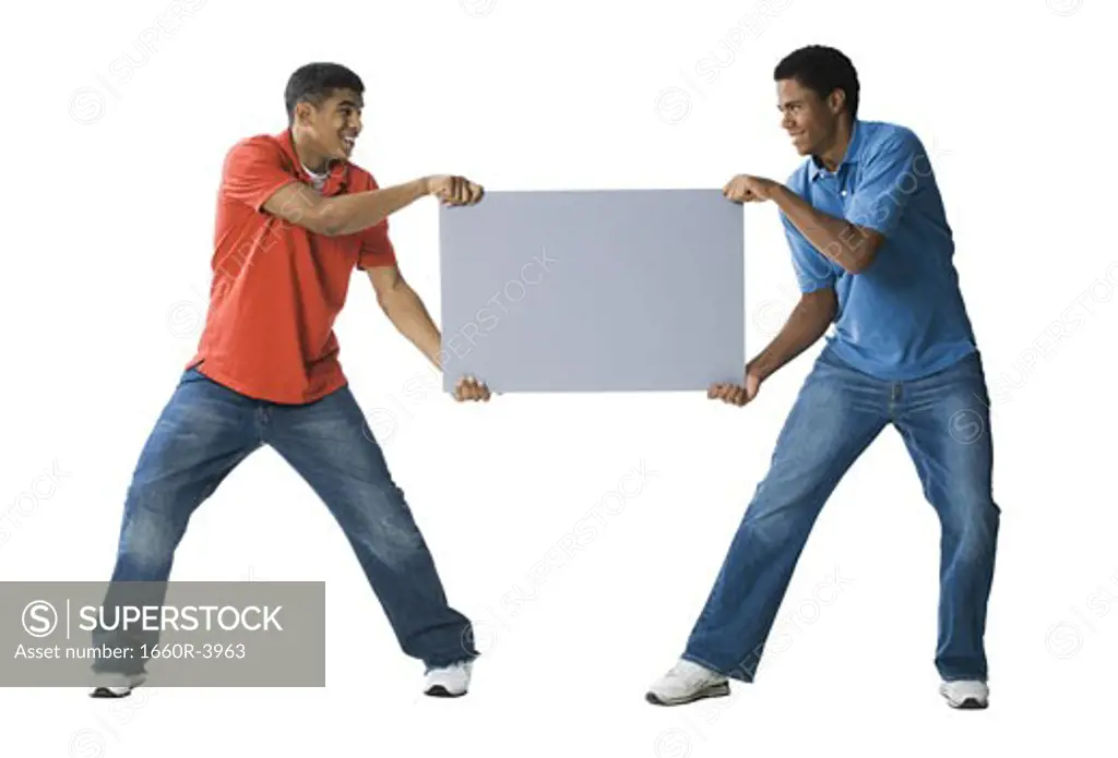 Two young men fighting over a blank sign