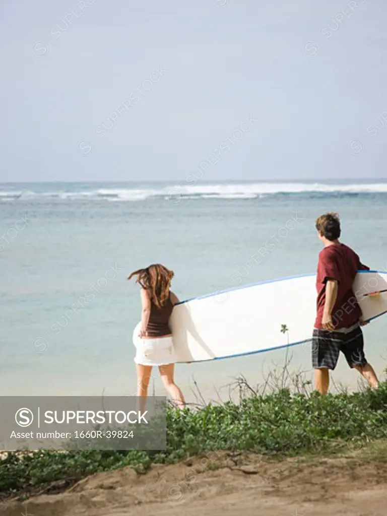 couple going to the beach to surf