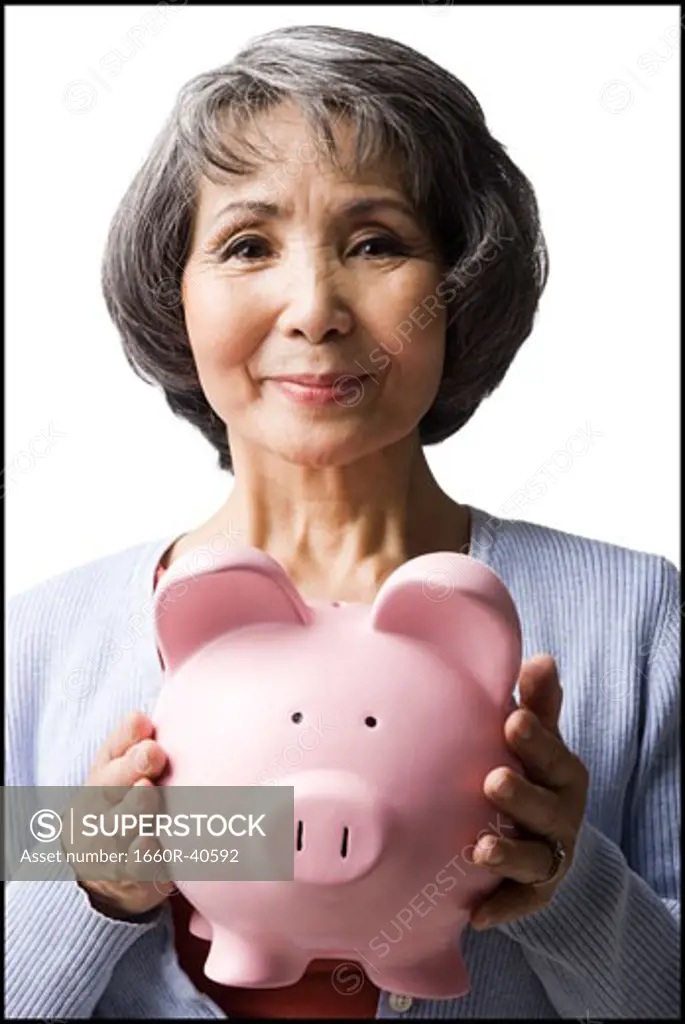 senior woman holding a piggy bank