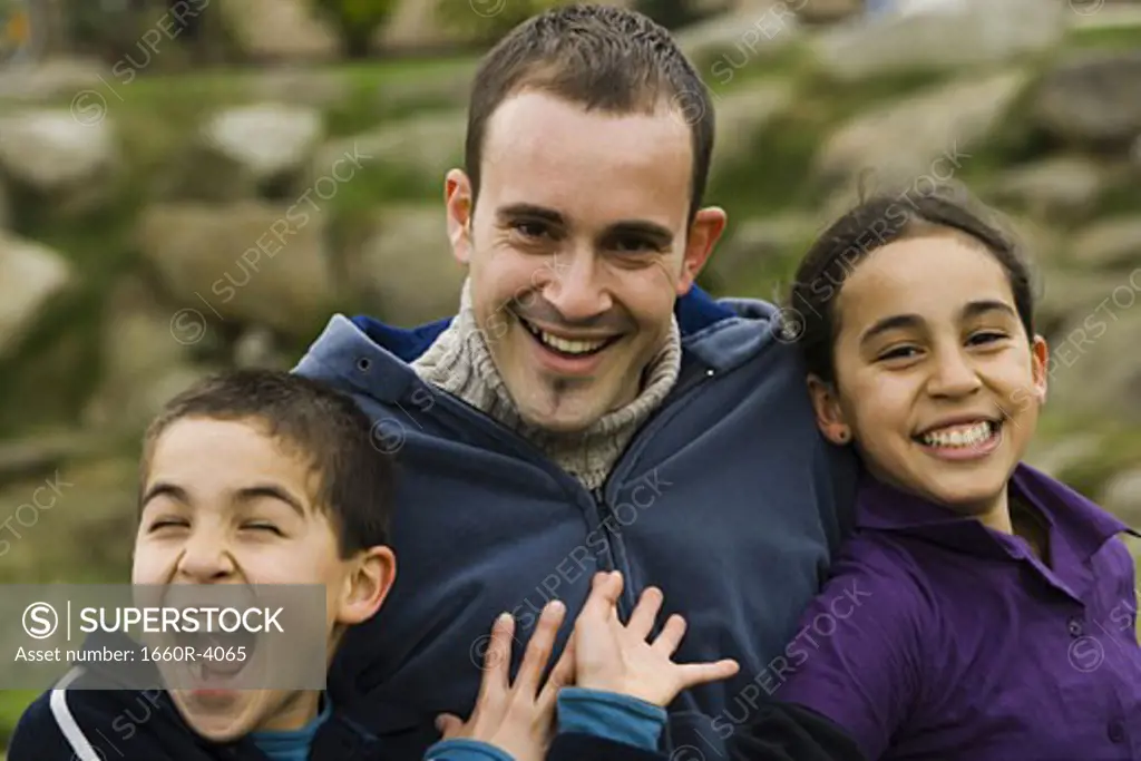 Close-up of a father with his son and daughter smiling