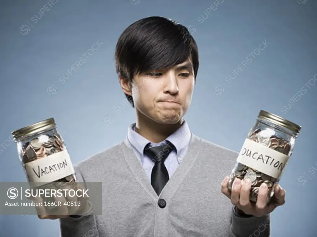 man holding two jars of coins