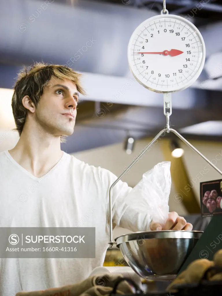 man using a scale at the supermarket