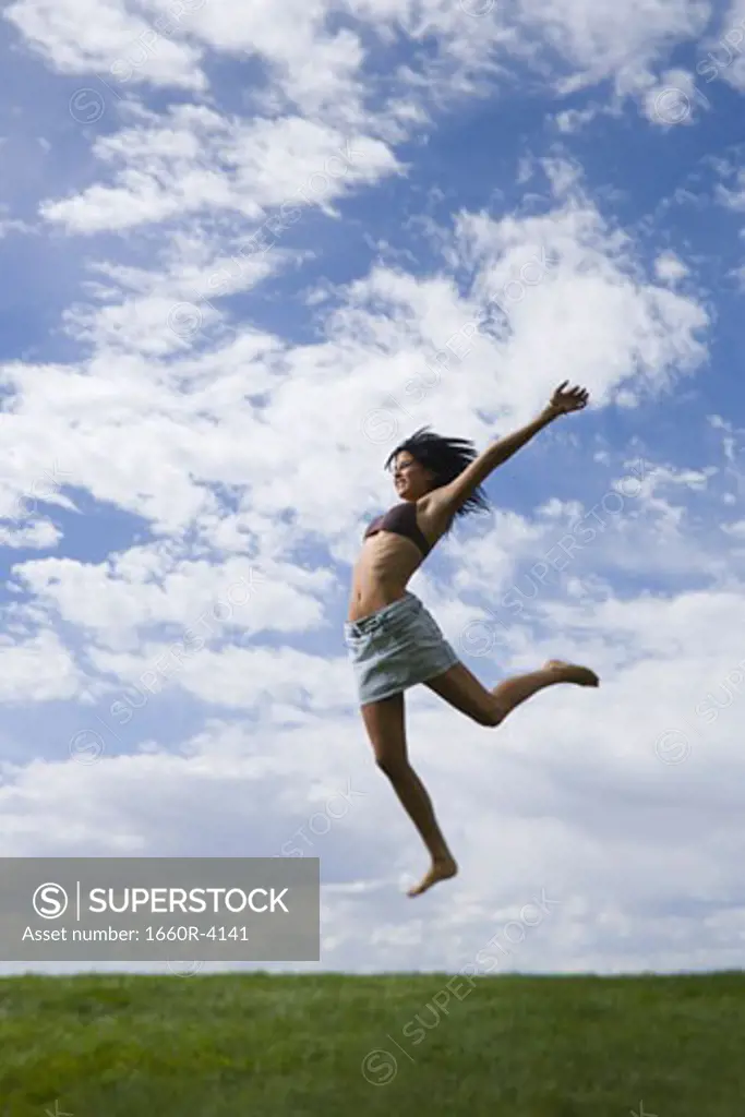 Profile of a young woman jumping