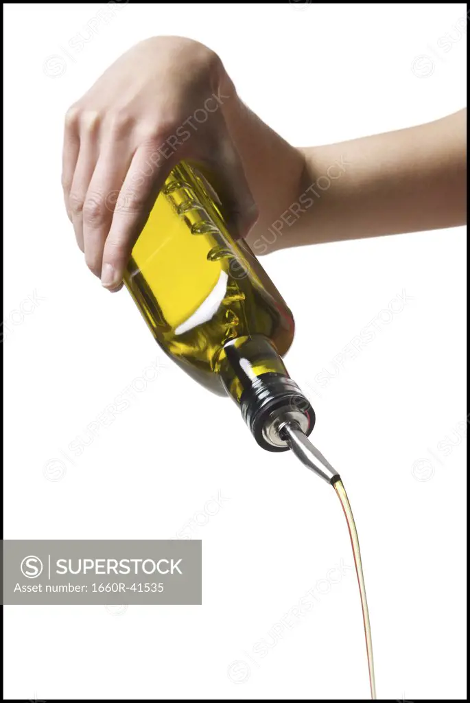 hand pouring olive oil
