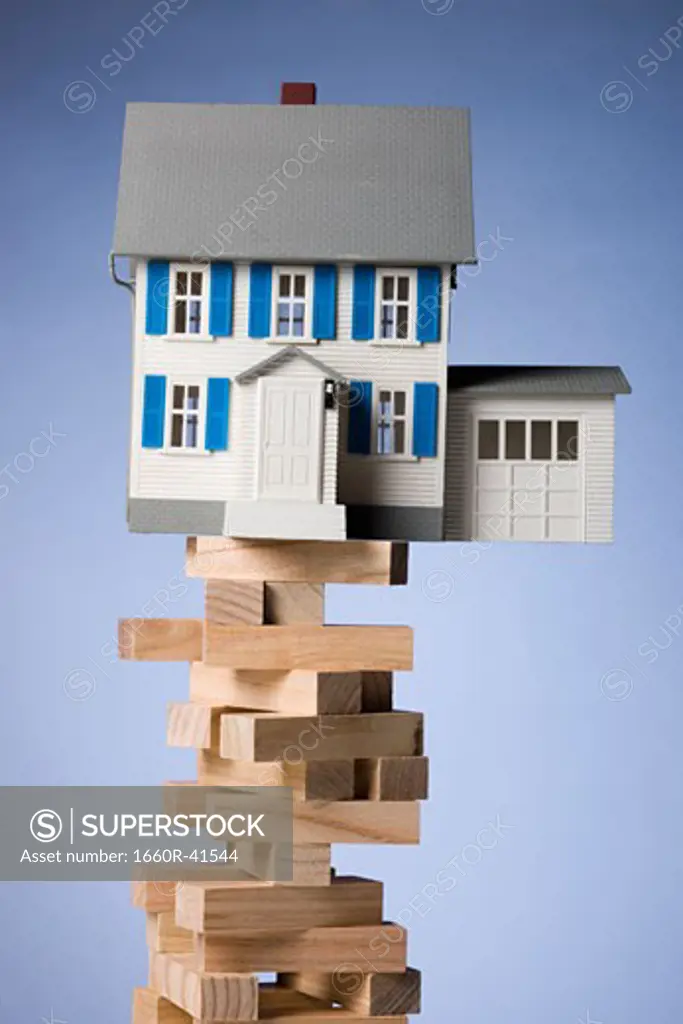 house perched precariously on a tower of blocks