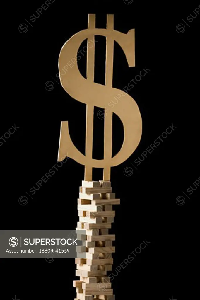 dollar symbol perched on a tower of blocks