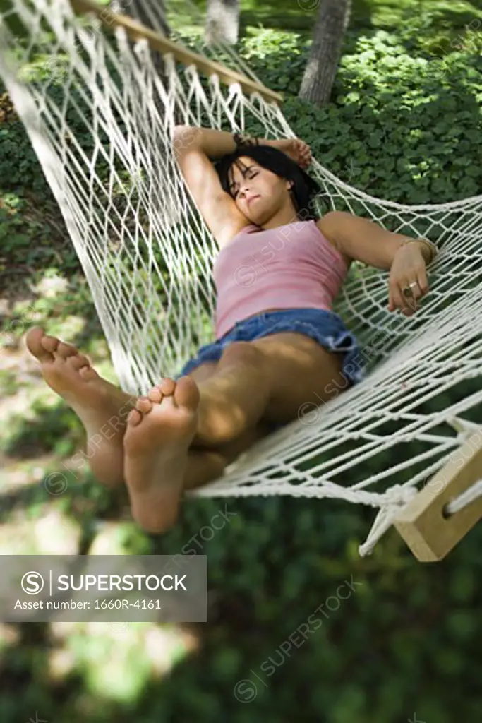 High angle view of a young woman sleeping in a hammock