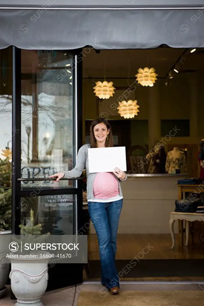 pregnant woman holding up a sign