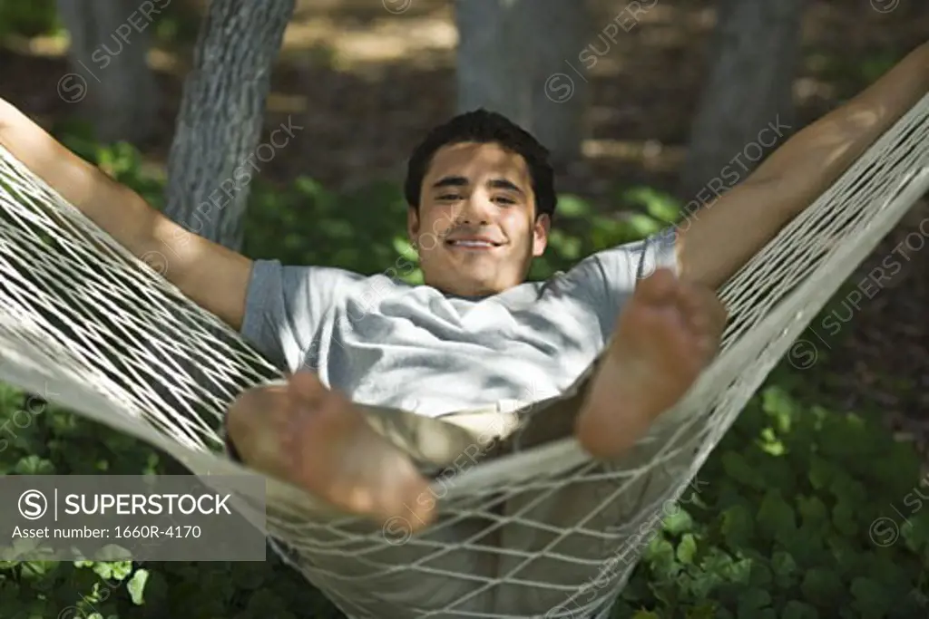 Portrait of a young man relaxing in a hammock
