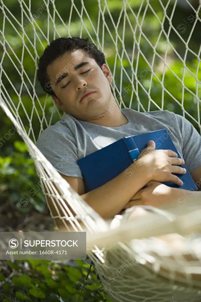 High angle view of a young man sleeping in hammock