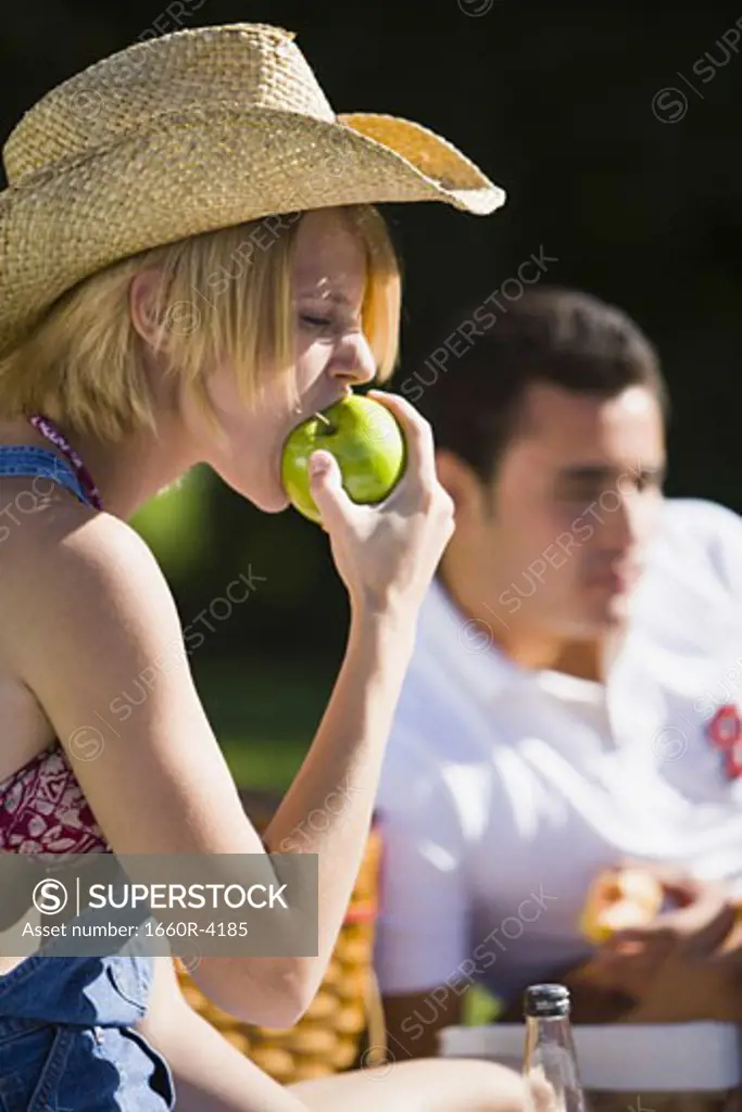 Close-up of a young woman biting an apple