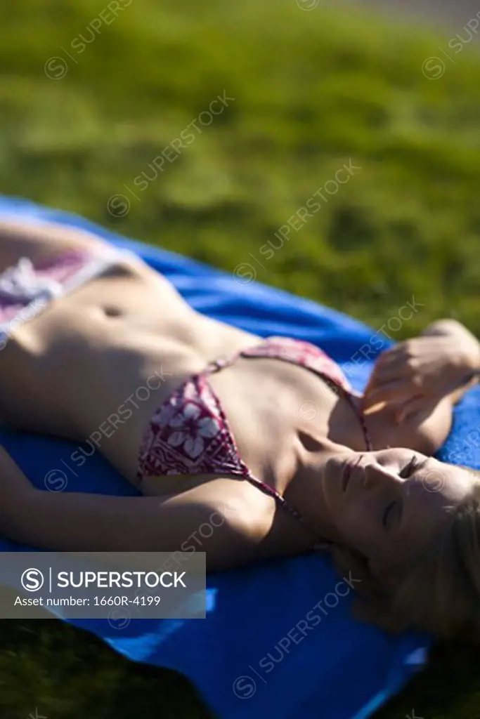 High angle view of a young woman lying down on a field