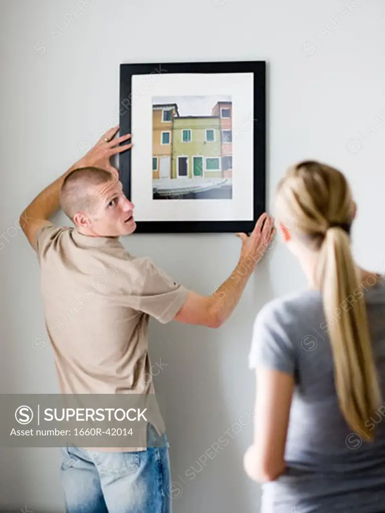 couple hanging a picture