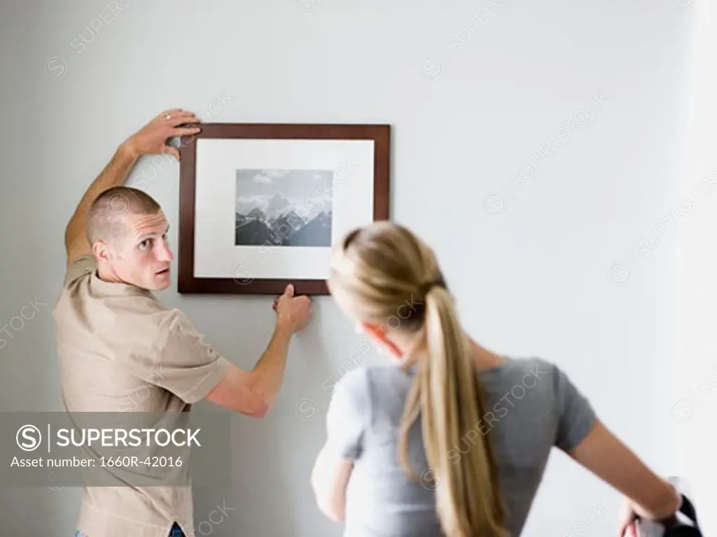couple hanging a picture