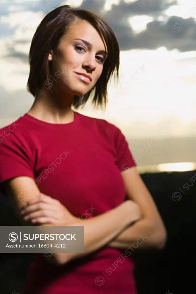 Portrait of a young woman standing with her arms crossed