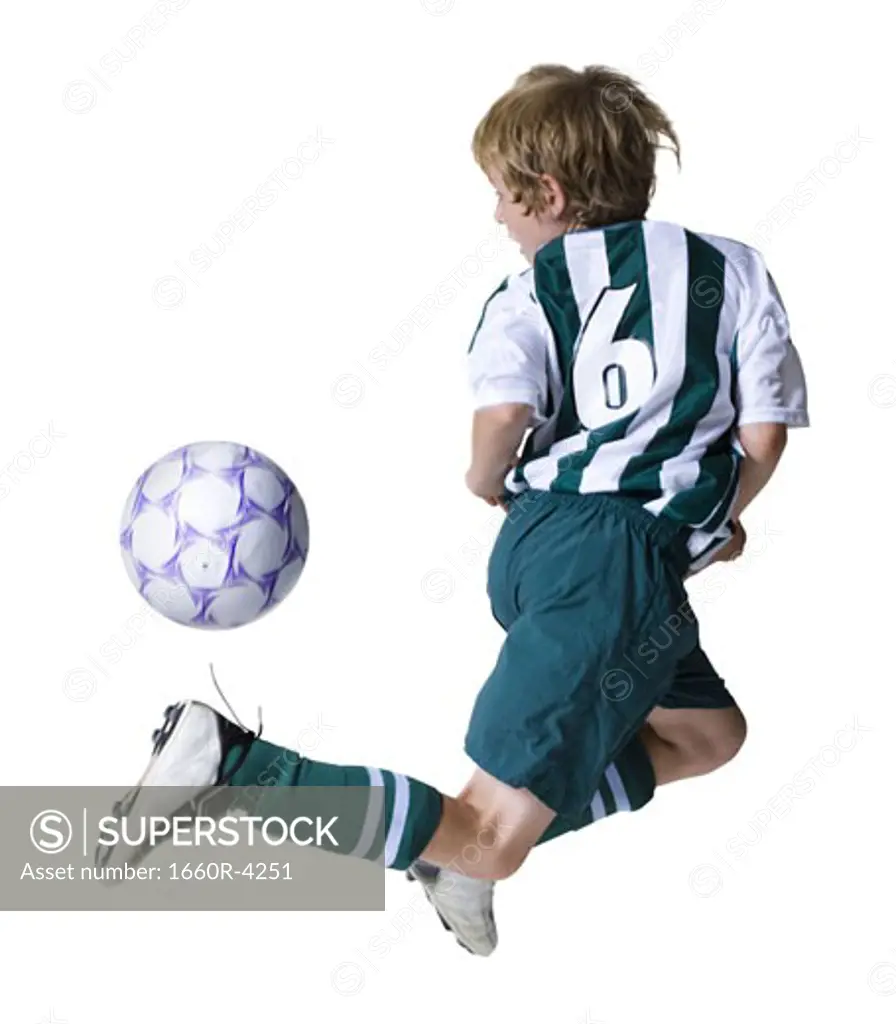 Rear view of a boy playing a soccer ball
