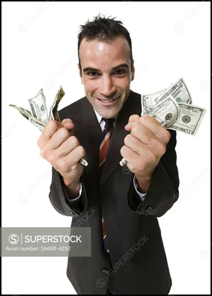 Businessman holding fists full of money