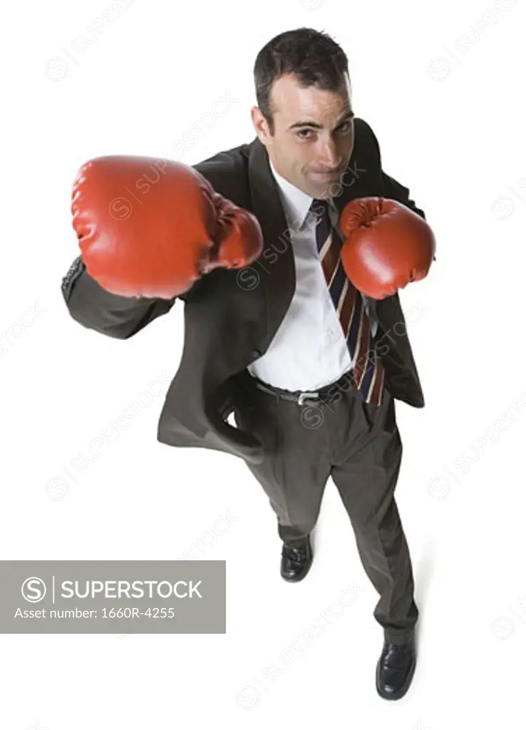 High angle view of a businessman wearing boxing gloves and punching