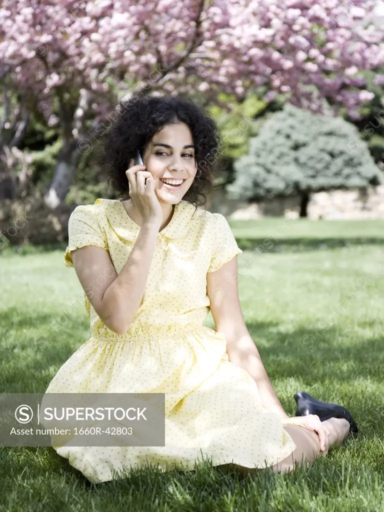 woman in a yellow dress on the phone