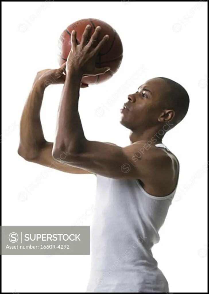 Portrait of a young man shooting a basketball