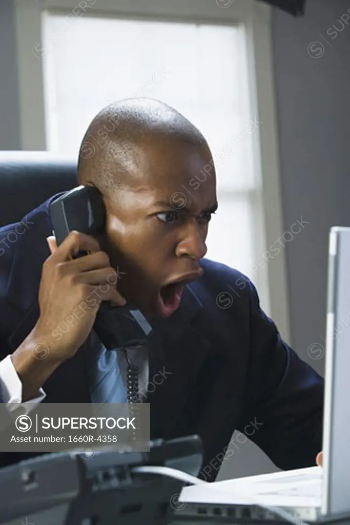 Close-up of a businessman shouting on the phone
