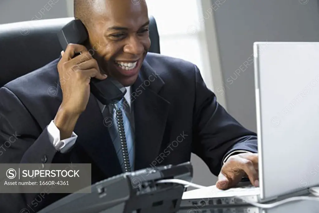 Close-up of a businessman smiling and talking on the phone