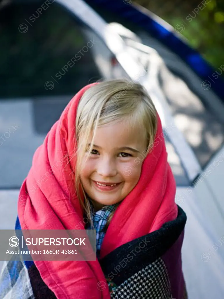 girl wrapped in a blanket in her backyard