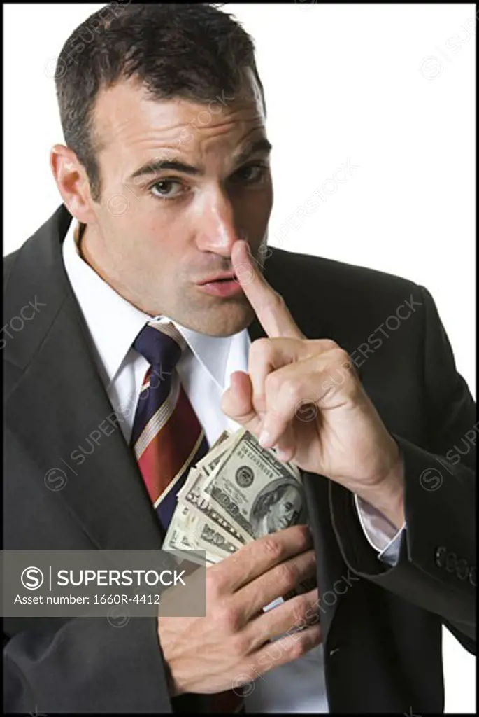 Portrait of a businessman putting money in his jacket