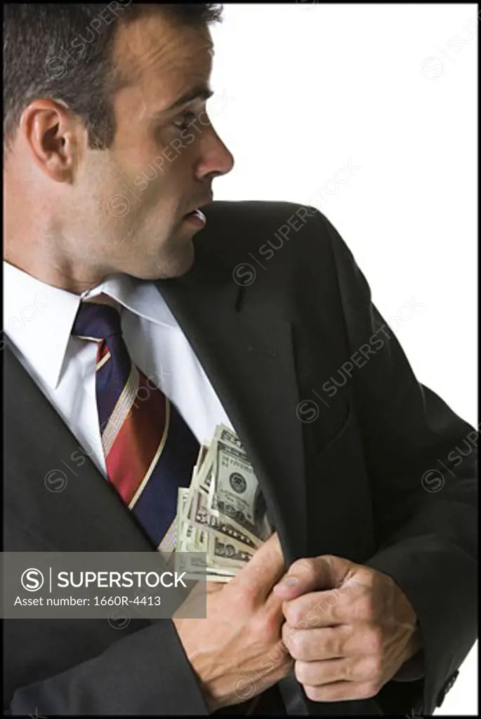 Businessman putting money in his jacket