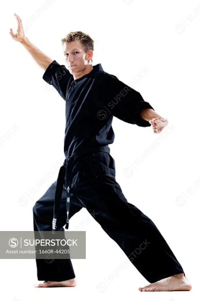 man in a black karate gi practicing martial arts