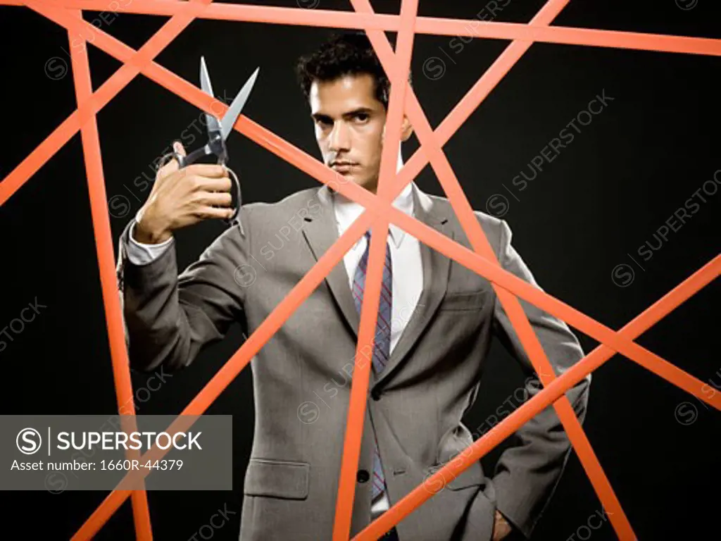 businessman cutting through the red tape