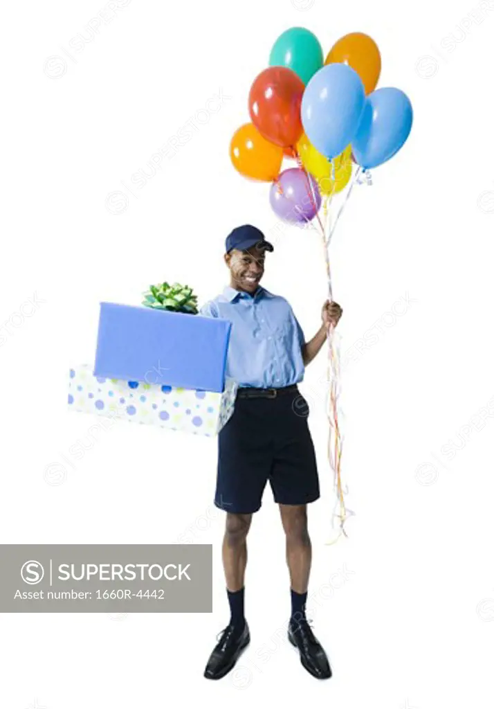 Portrait of a delivery man holding gifts and balloons