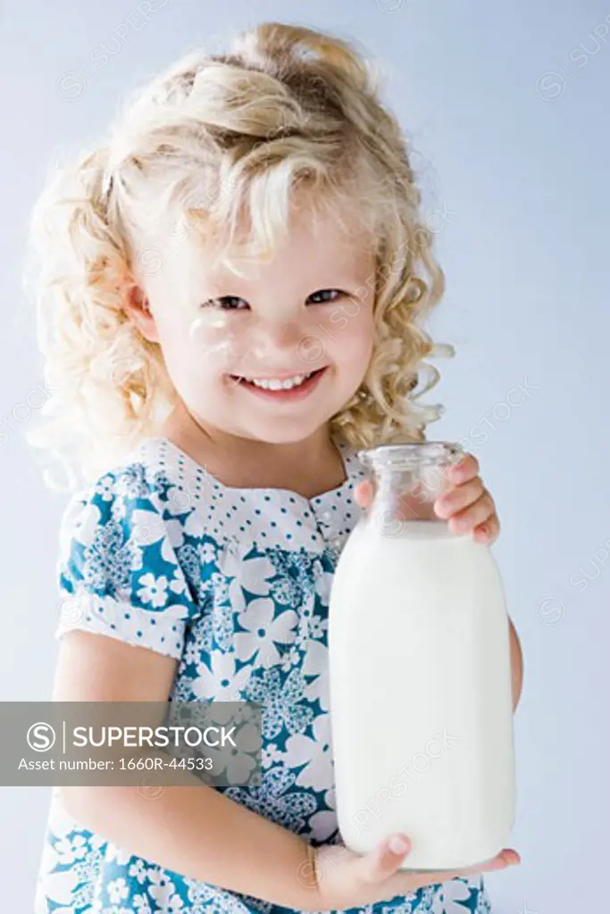 little girl holding a jug of milk