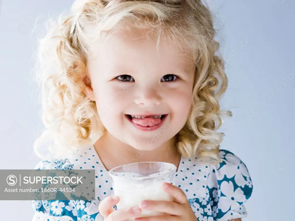 little girl holding a glass of milk
