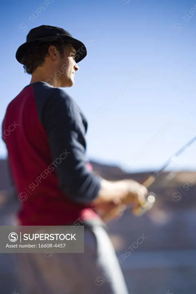 Low angle view of a young man fishing