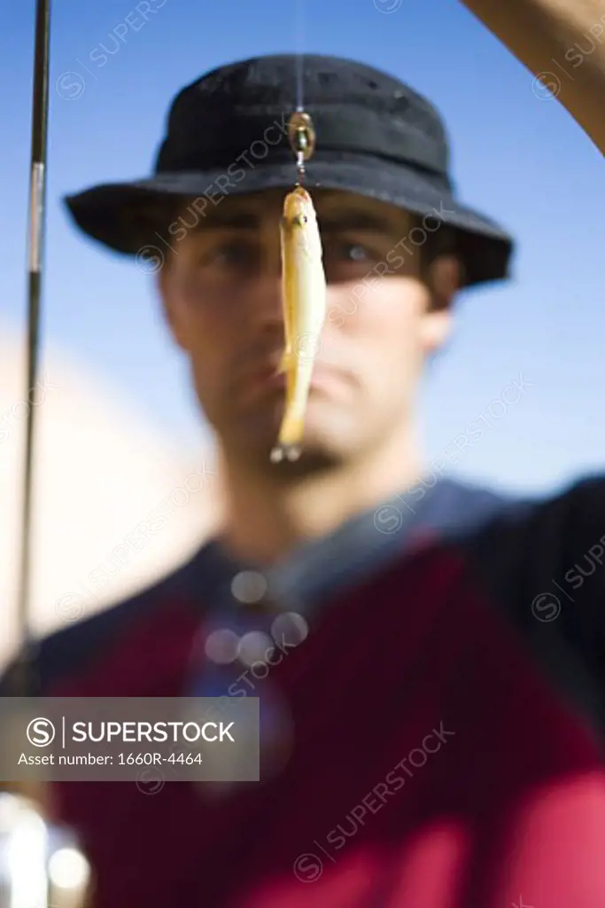 Close-up of a young man looking at a fishing bait