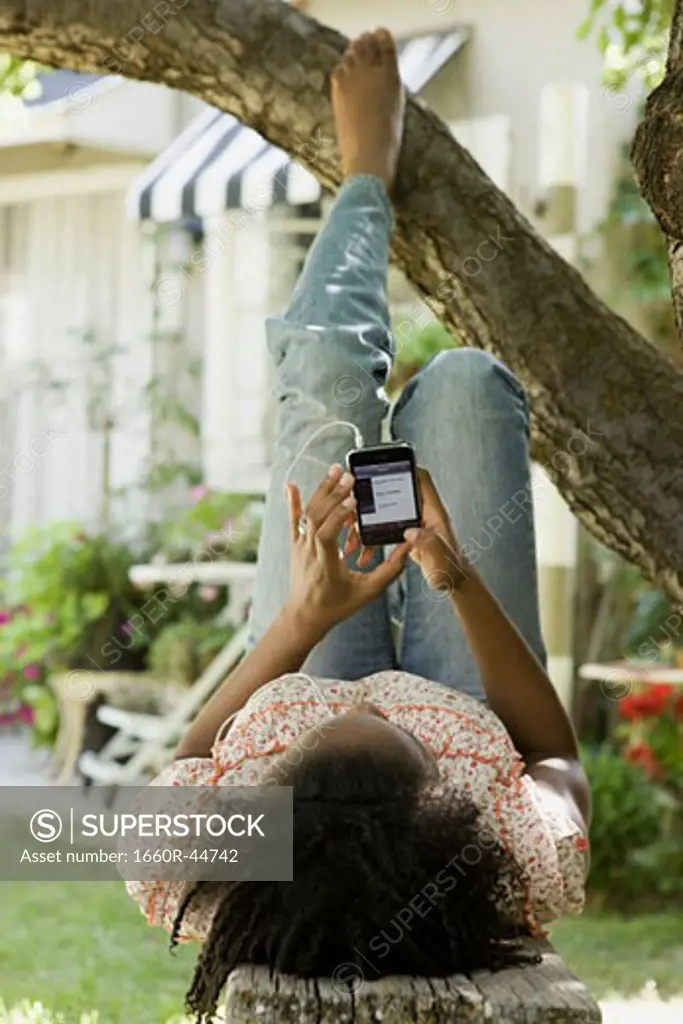 woman in the backyard listening to a digital music player