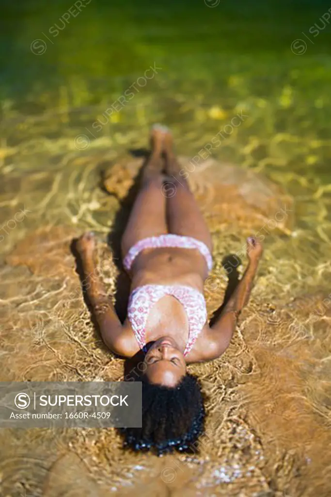High angle view of a young woman lying in water