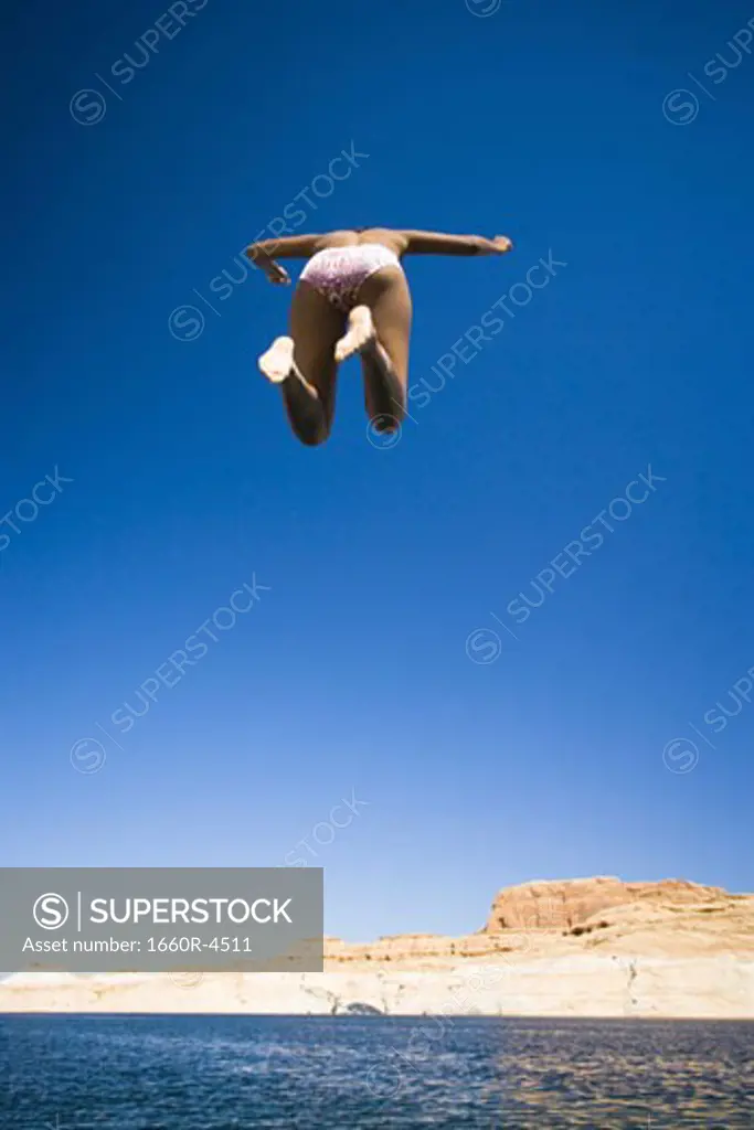 Low angle view of a young woman jumping in water