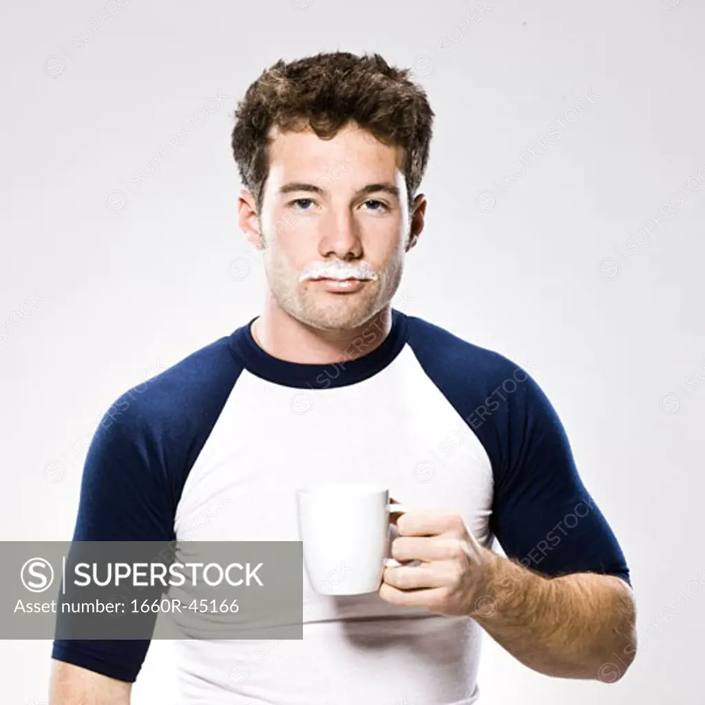 man with a milk moustache holding a white mug