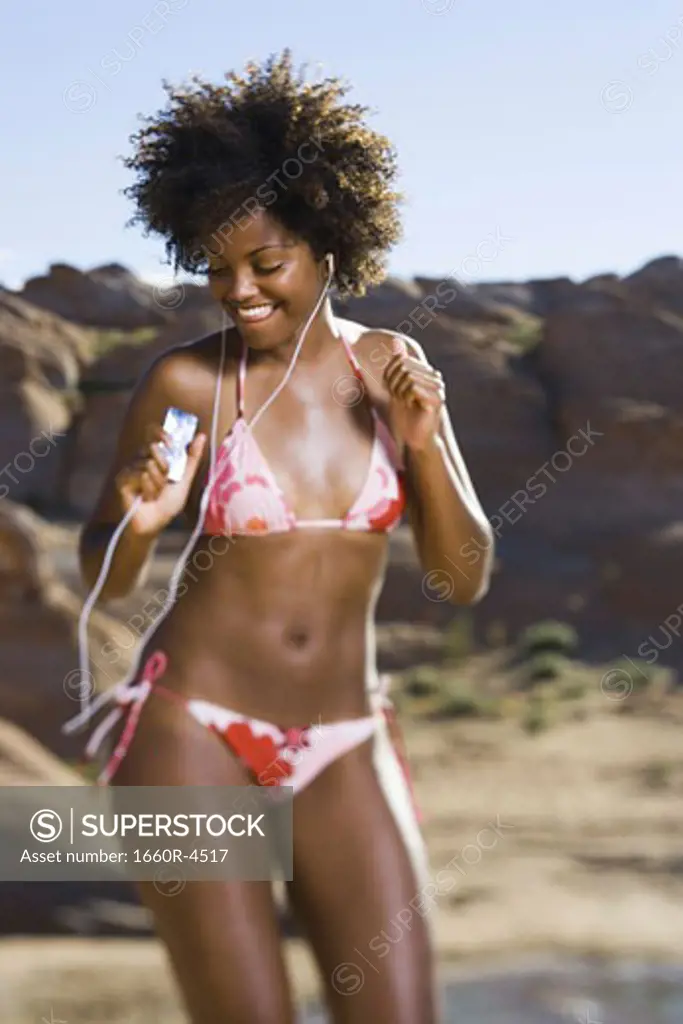Young woman listening to an MP3 Player and dancing