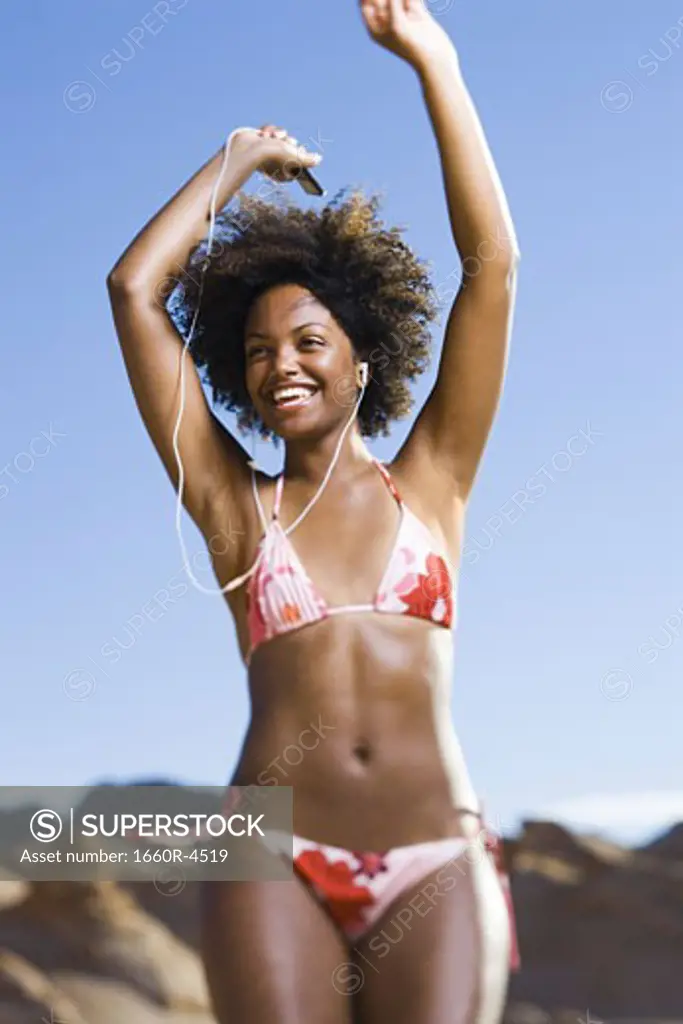 Low angle view of a young woman dancing with listening to an MP3 Player