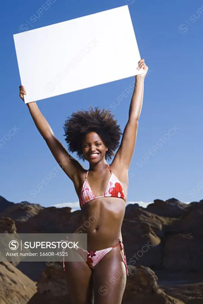 Portrait of a young woman holding up a blank sign