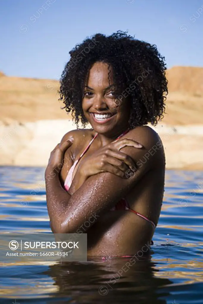 Portrait of a young woman in a lake, smiling