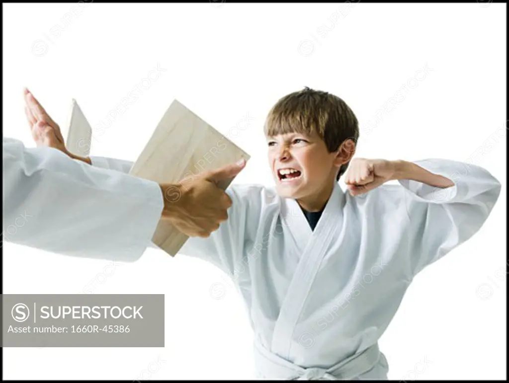 boy breaking a board using karate
