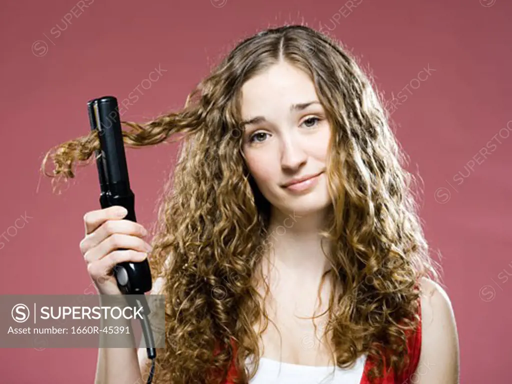 woman trying to straighten her hair