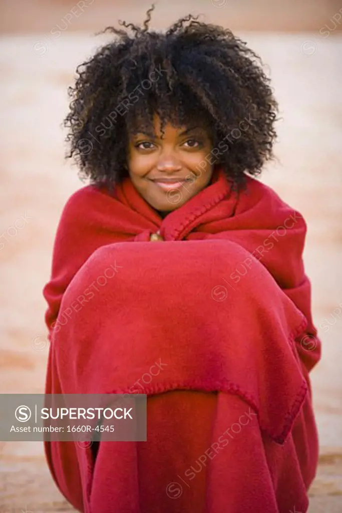 Portrait of a young woman wrapped in a towel and smiling